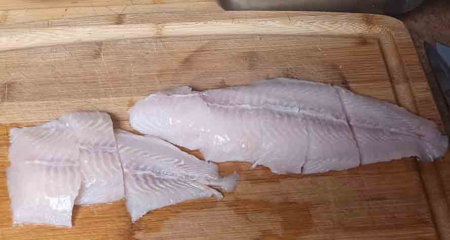 Cutting fish flets for the sandwich.