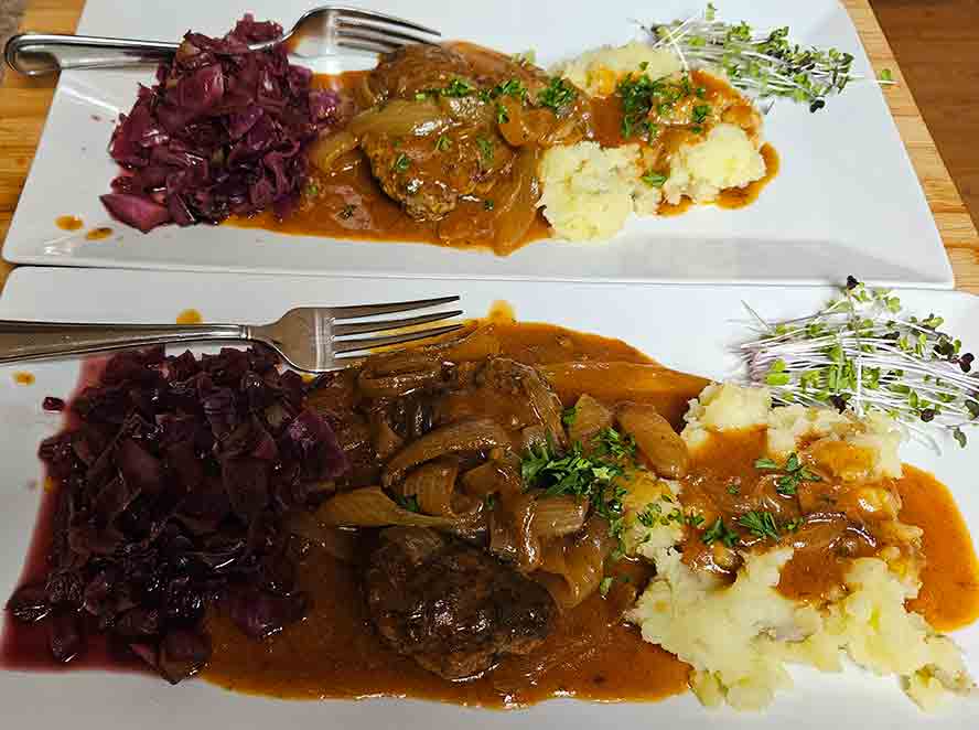 Finished Frikadellen in Onion Sauce with mashed potato and sweet and sour purple cabbage. 